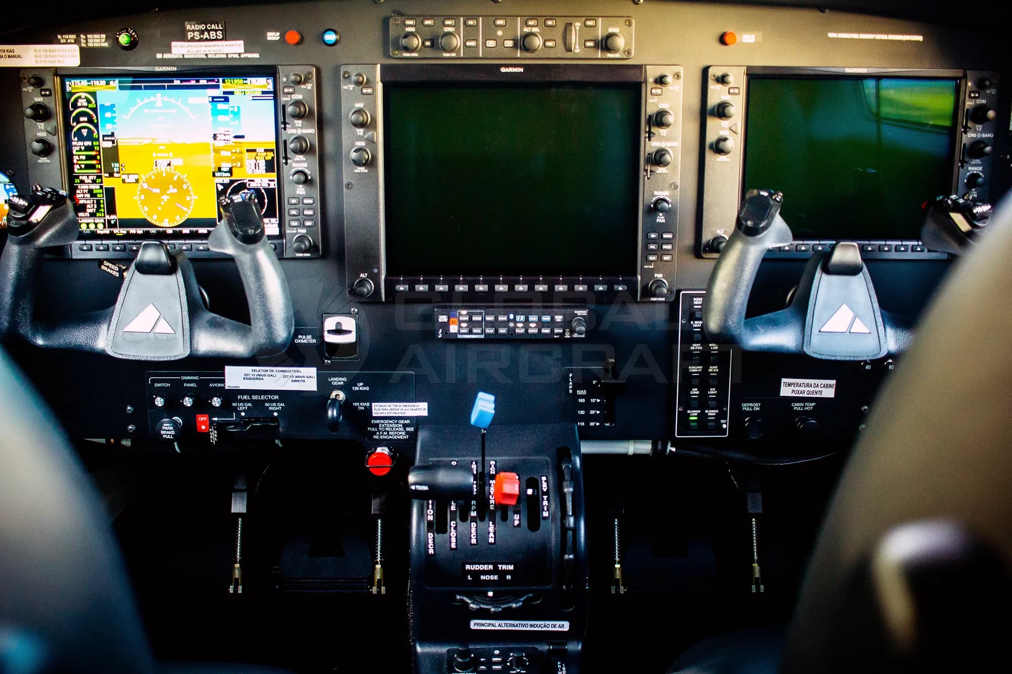 The cockpit of a Piper M350 aircraft, showing the Garmin avionics suite, yokes, and central console.