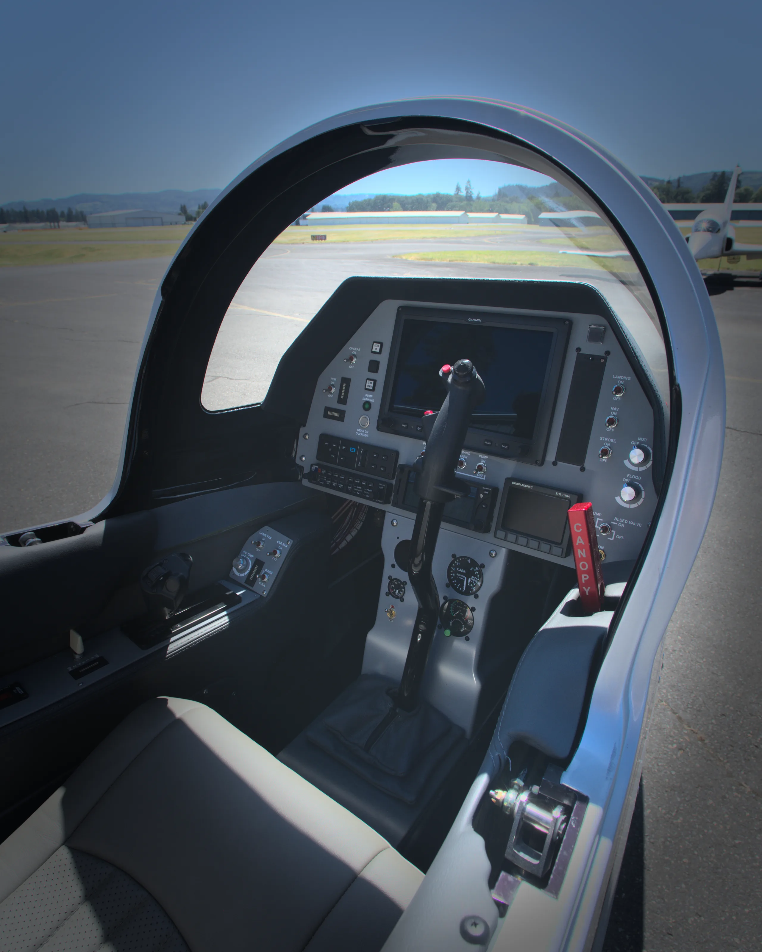 The modern cockpit of a Viperjet aircraft, showing the instrument panel, stick, and view of the runway.