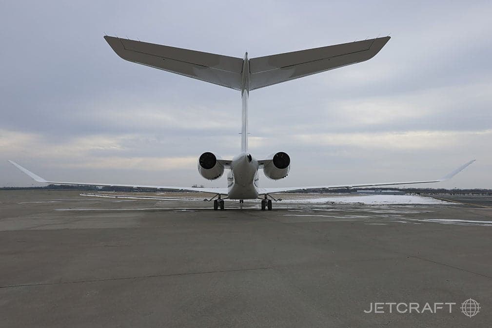 Rear view of a white jet on the tarmac.