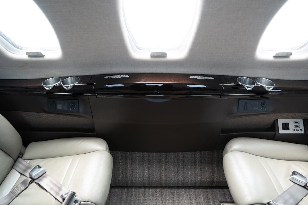 View of the aircraft's interior cabin showing the overhead console and leather seats.