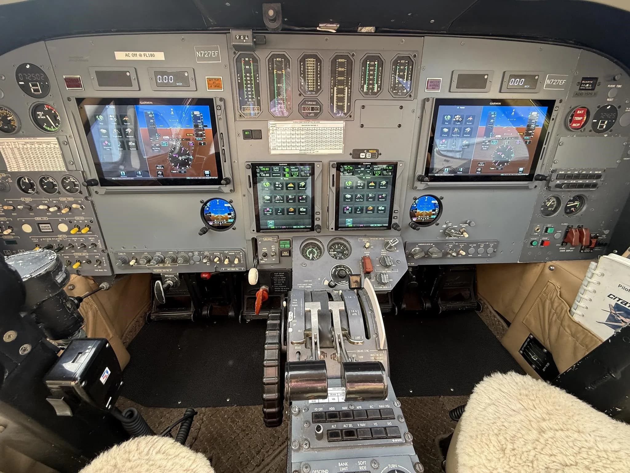 The cockpit of a Cessna Citation jet, featuring a modern glass panel with multiple Garmin displays and traditional controls.