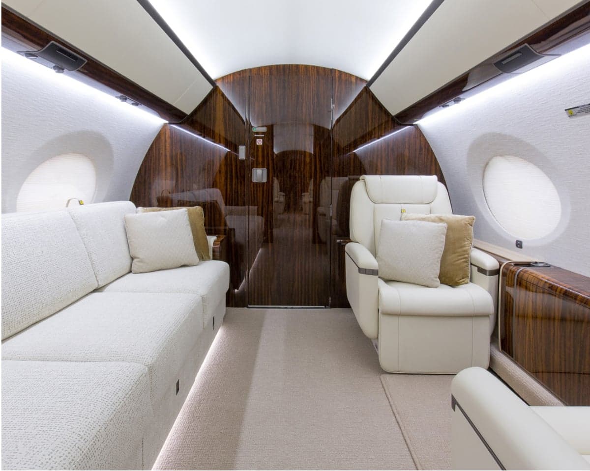 A view of the aircraft's interior with a sofa and chairs.