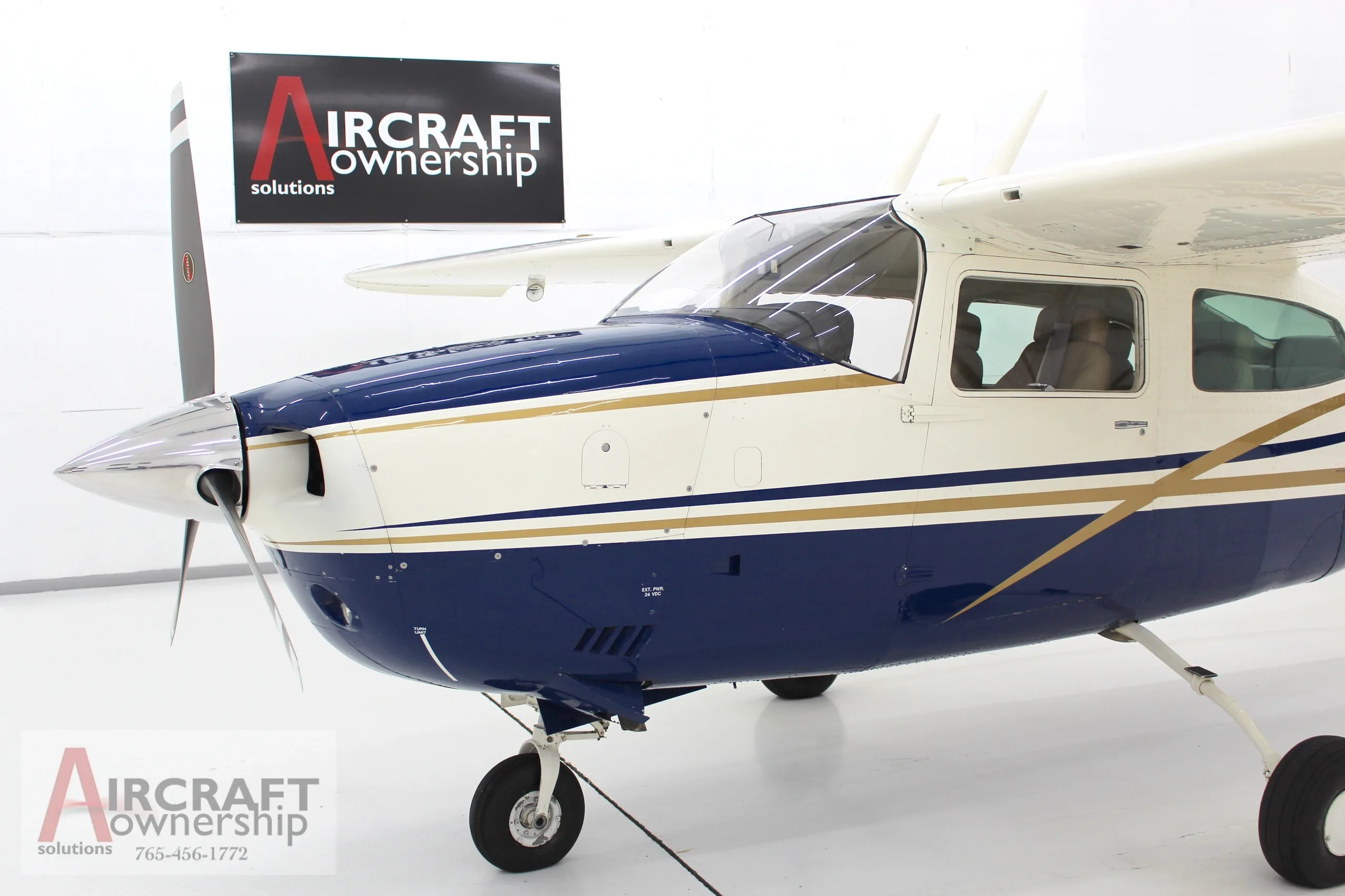 Front view of a blue and white Cessna 206 aircraft, N5091V, showing the propeller and nose.
