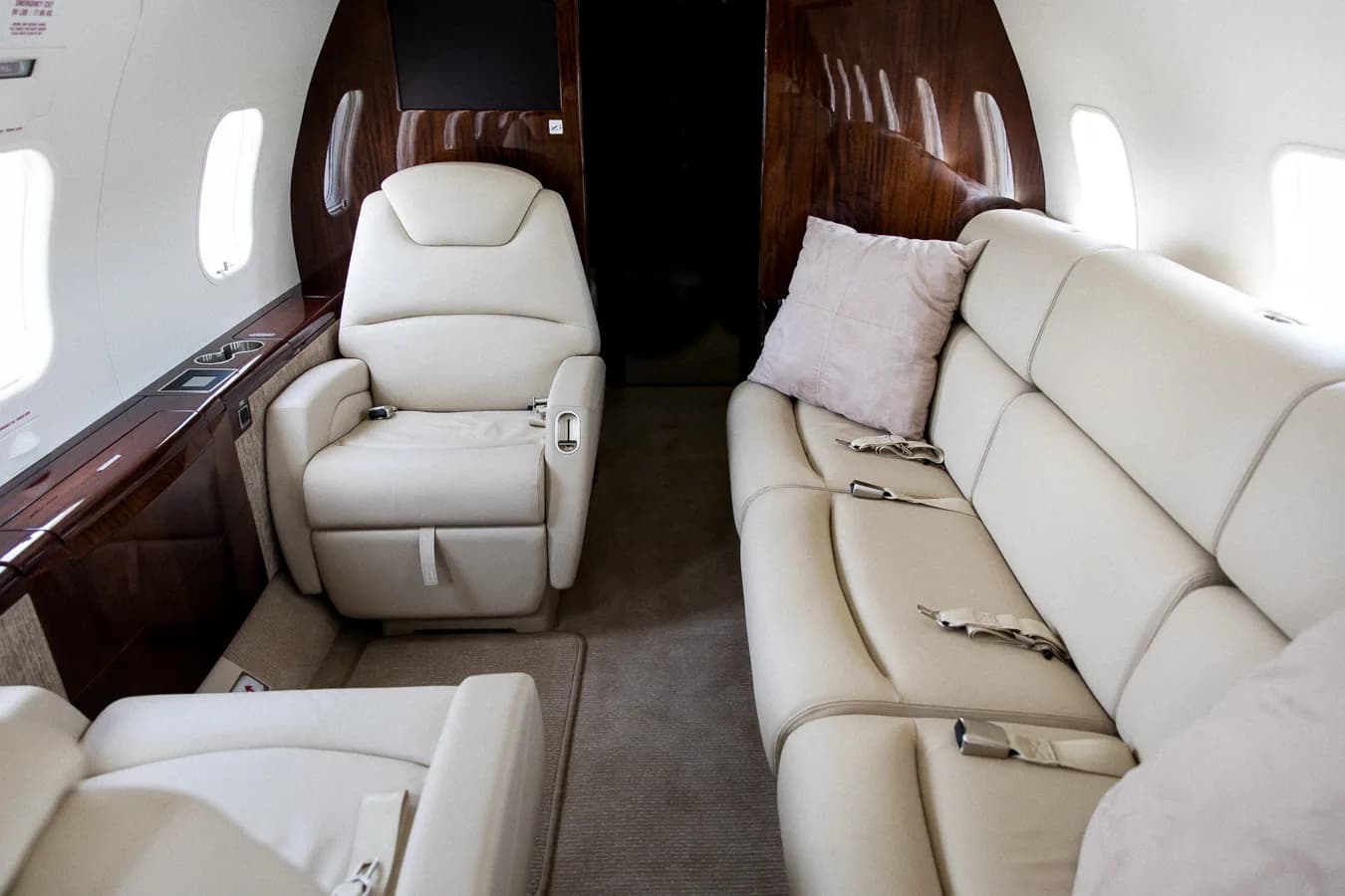 View of the aircraft interior with leather seats and wood trim.