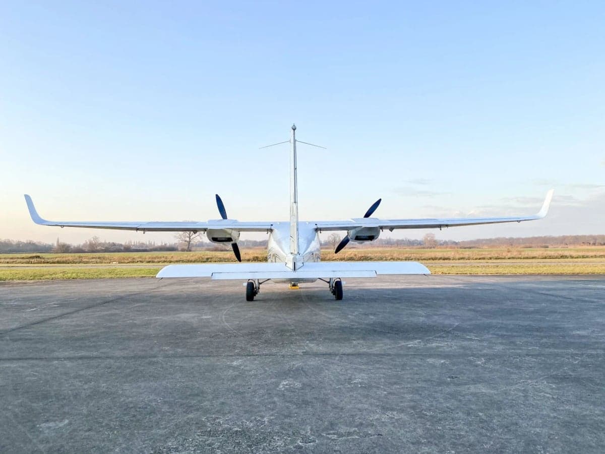 Tecnam P2006T D-GTIM parked near a hangar at sunset