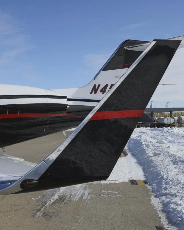 Tail section of an aircraft with black and red striping and the registration number N45JG.