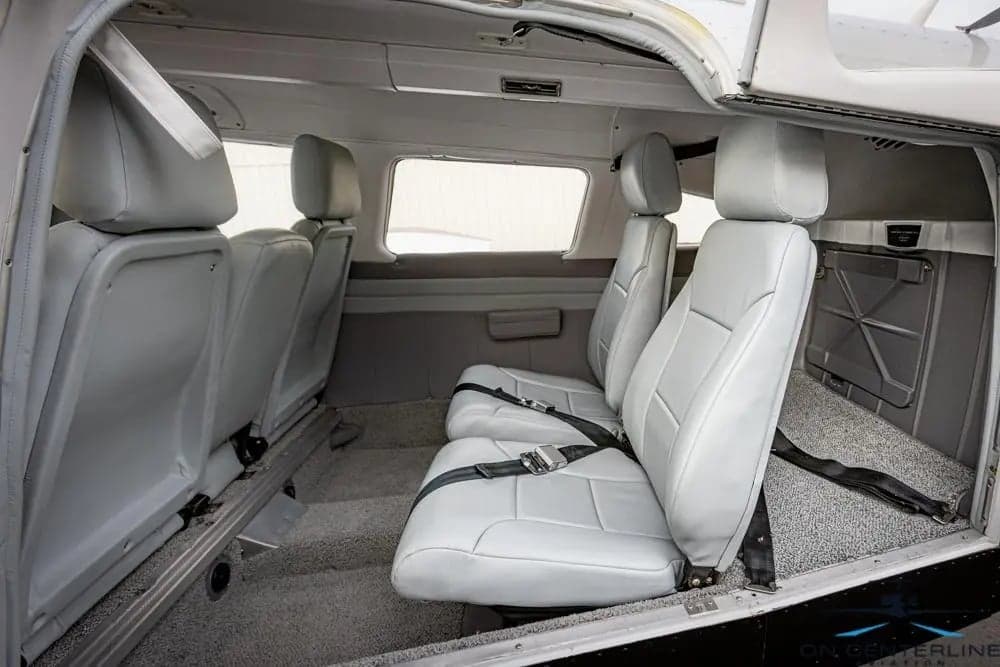View of the cabin of a Piper PA-32R-301 Saratoga SP, featuring gray leather seats and gray carpet.