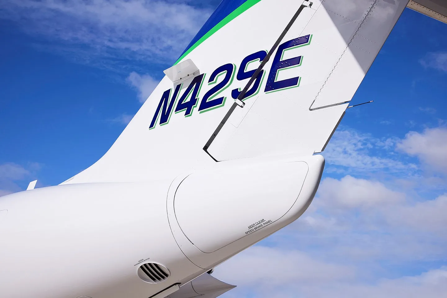 Close-up of the white tail of a HondaJet Elite, showing the registration N42SE against a blue sky.