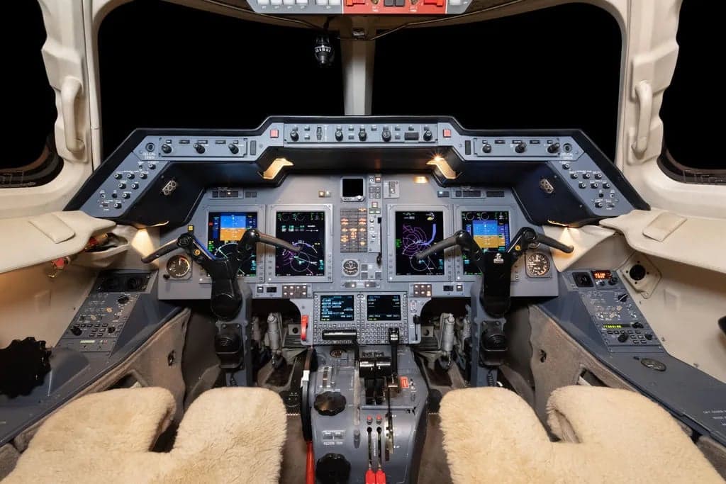 View of the aircraft's cockpit featuring the instrument panel and controls.