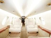 The aircraft's interior features cream-colored leather seats.
