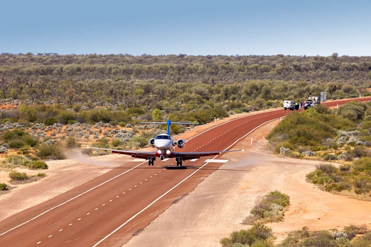 A Pilatus PC-24 aircraft landing on a remote runway.