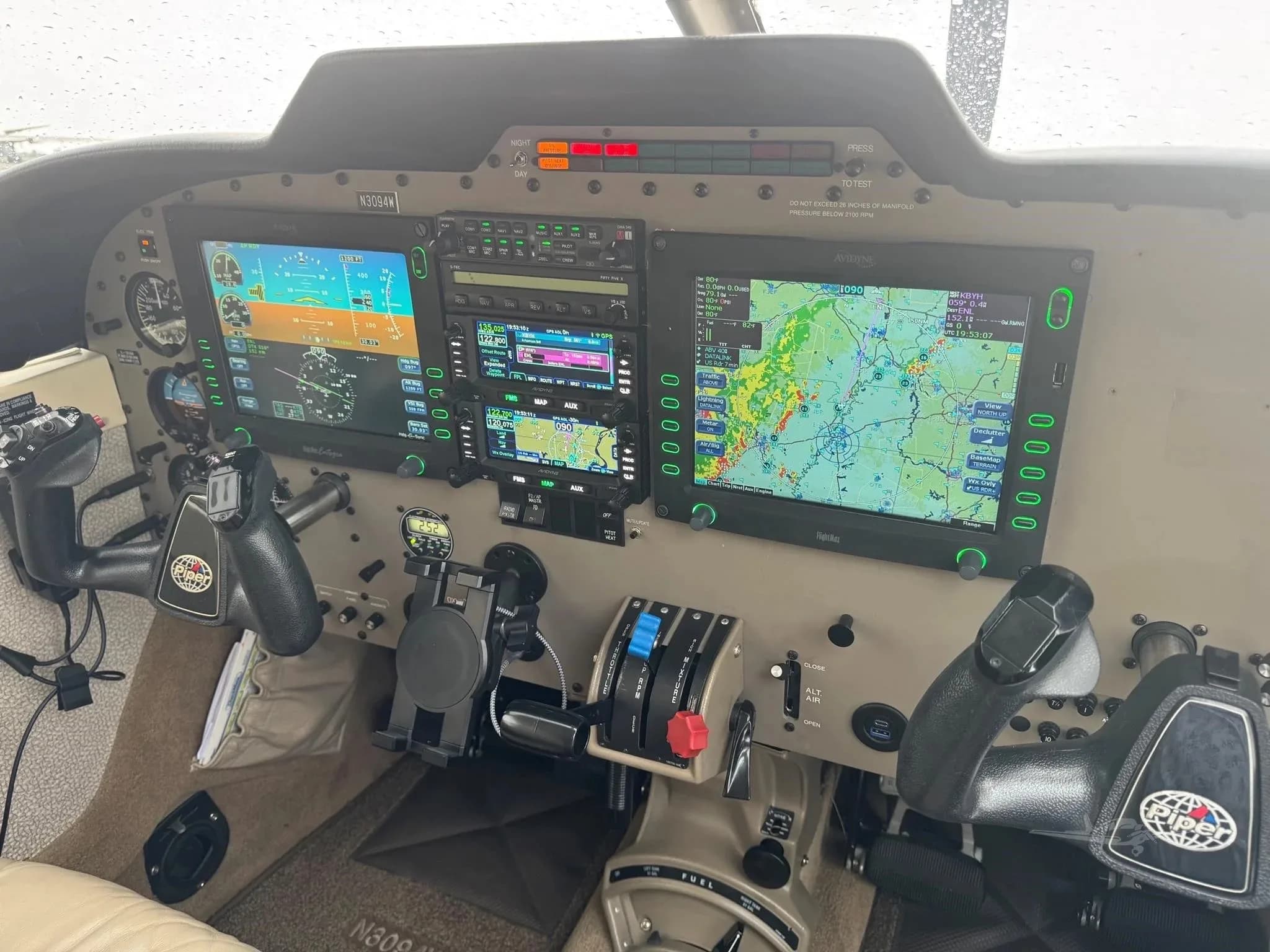 The cockpit of the Piper Malibu Mirage N3094W, featuring a modern glass panel with multiple displays and yokes.