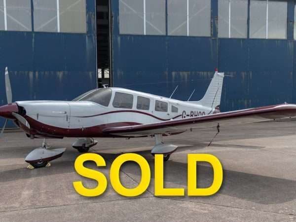 A Piper PA-28 Cherokee with a red and silver paint scheme is marked as SOLD.