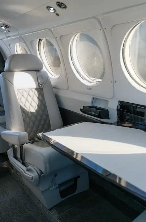 A seat and table inside the King Air B200 aircraft.