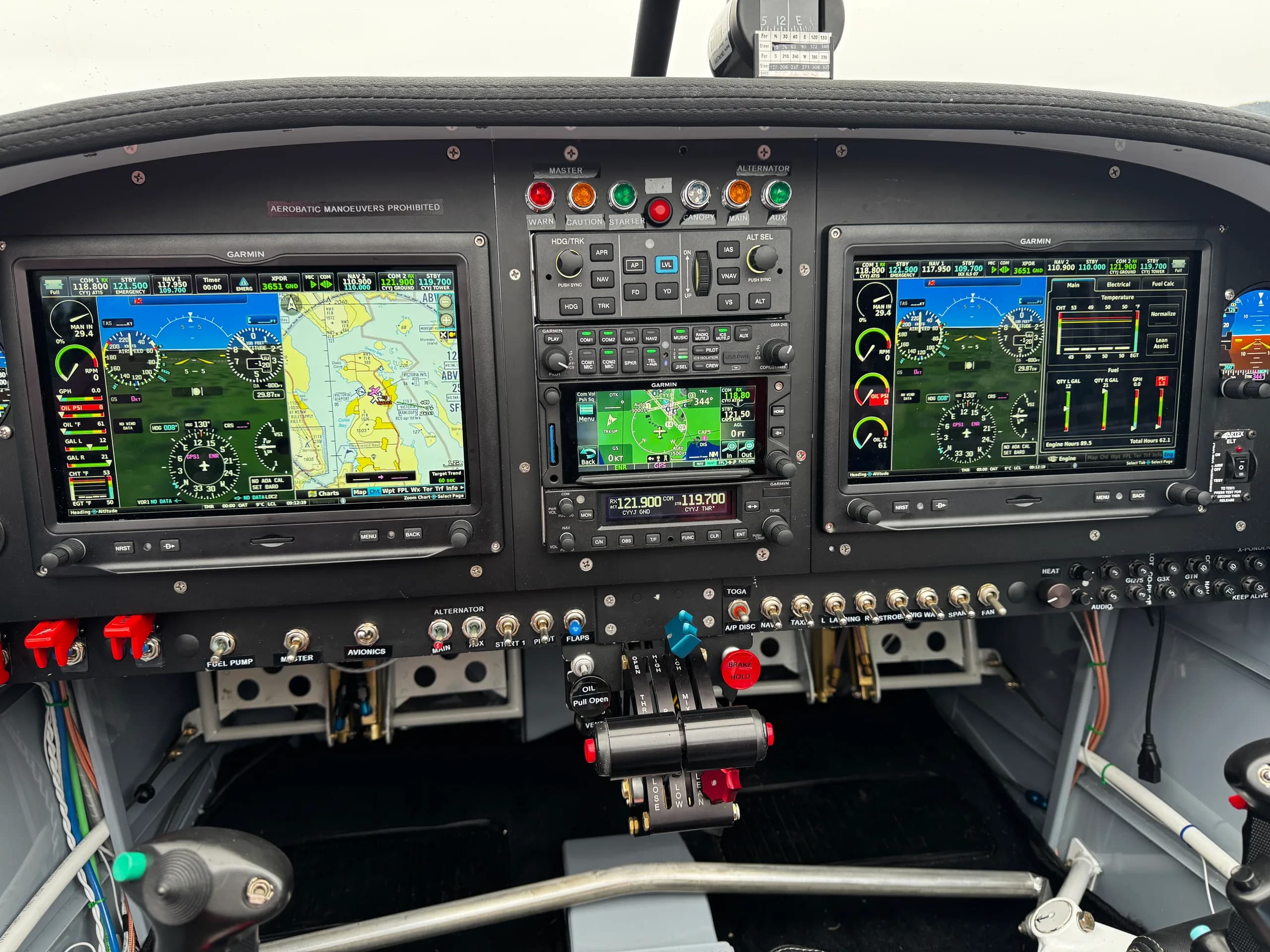 The aircraft's cockpit, featuring a wide view of the instrument panel with dual Garmin displays, a central radio stack, and flight controls.