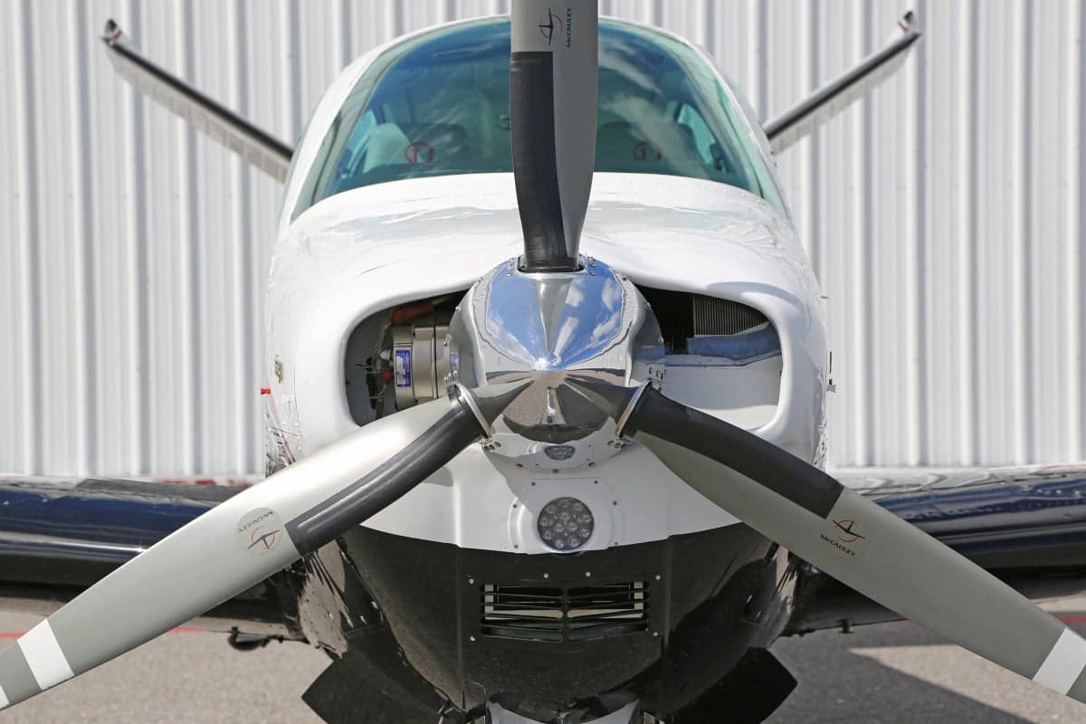 Extreme close-up of the propeller and nose of a Beechcraft Bonanza aircraft.