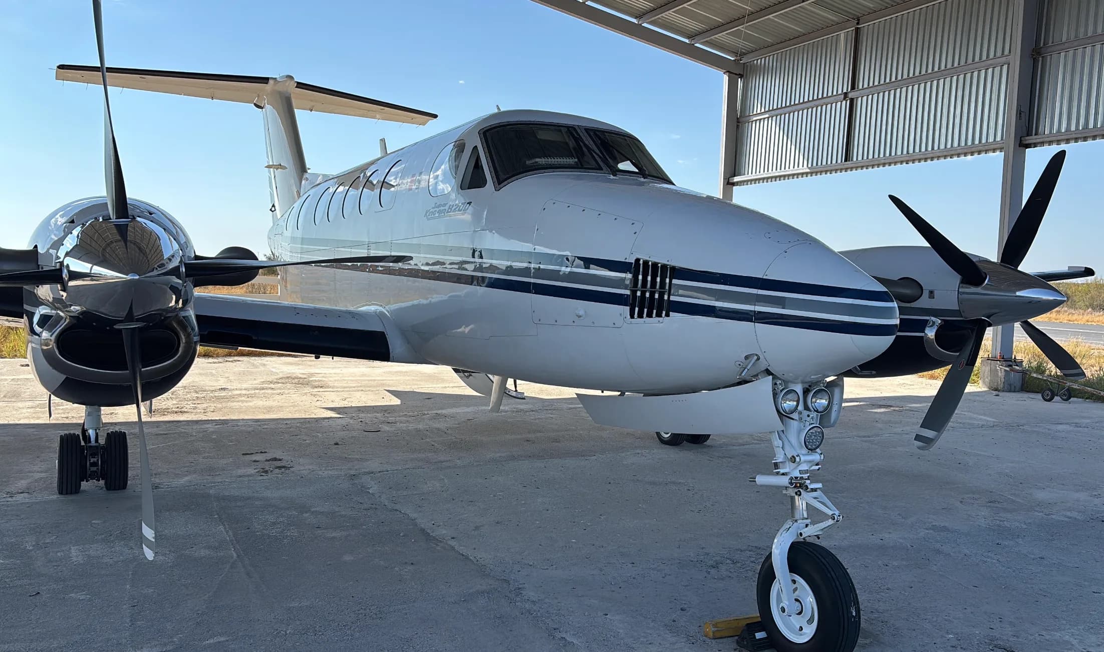 A Beechcraft King Air 350 is parked in a hangar with its landing gear visible.