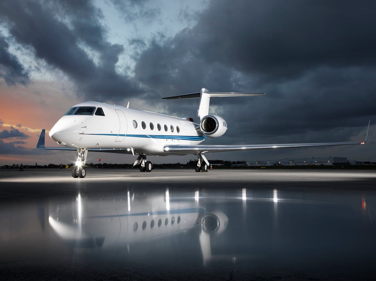 Front quarter view of the aircraft on the tarmac with a sunset sky.