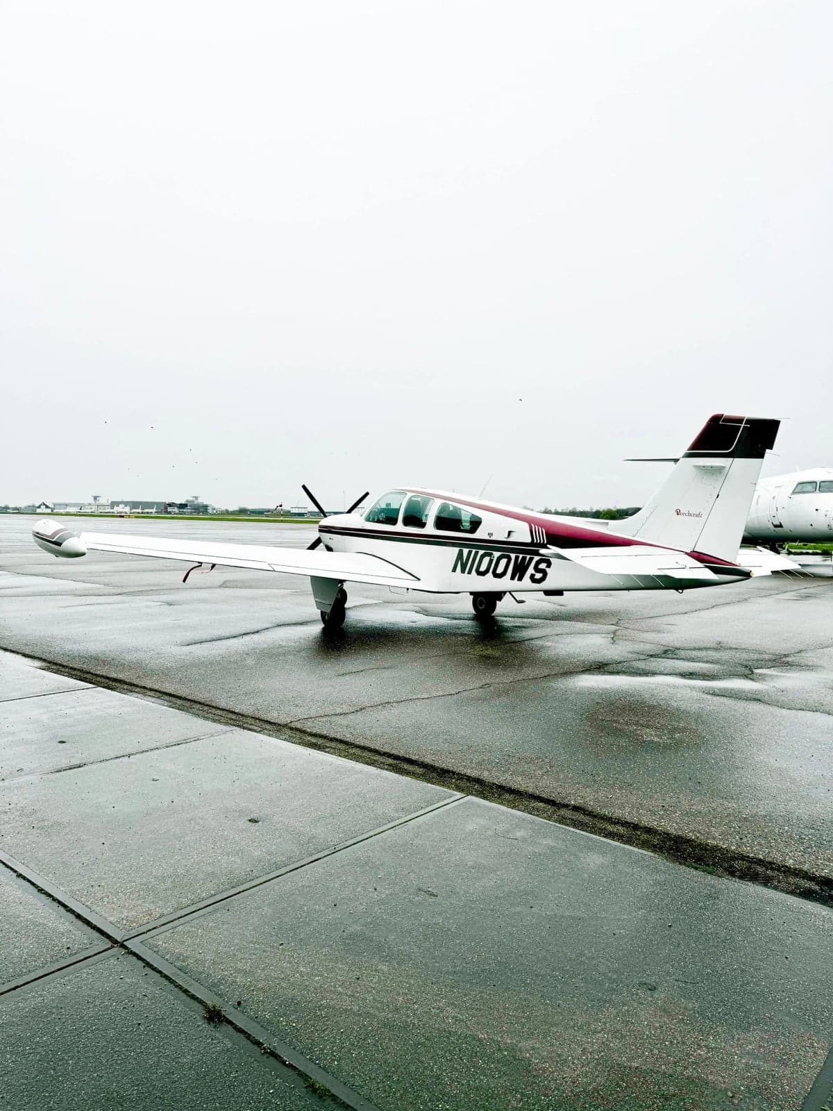 Side view of N100WS Bonanza aircraft parked on the tarmac.