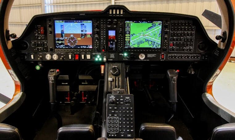 The cockpit of a Diamond DA62 aircraft features a modern glass panel display.
