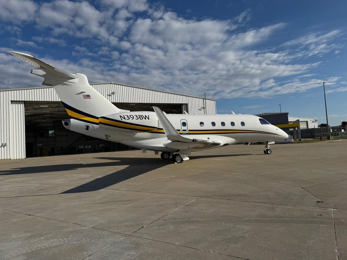 Side view of the aircraft N393BW parked outside a hangar.