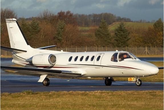 A white jet taxis on the runway.