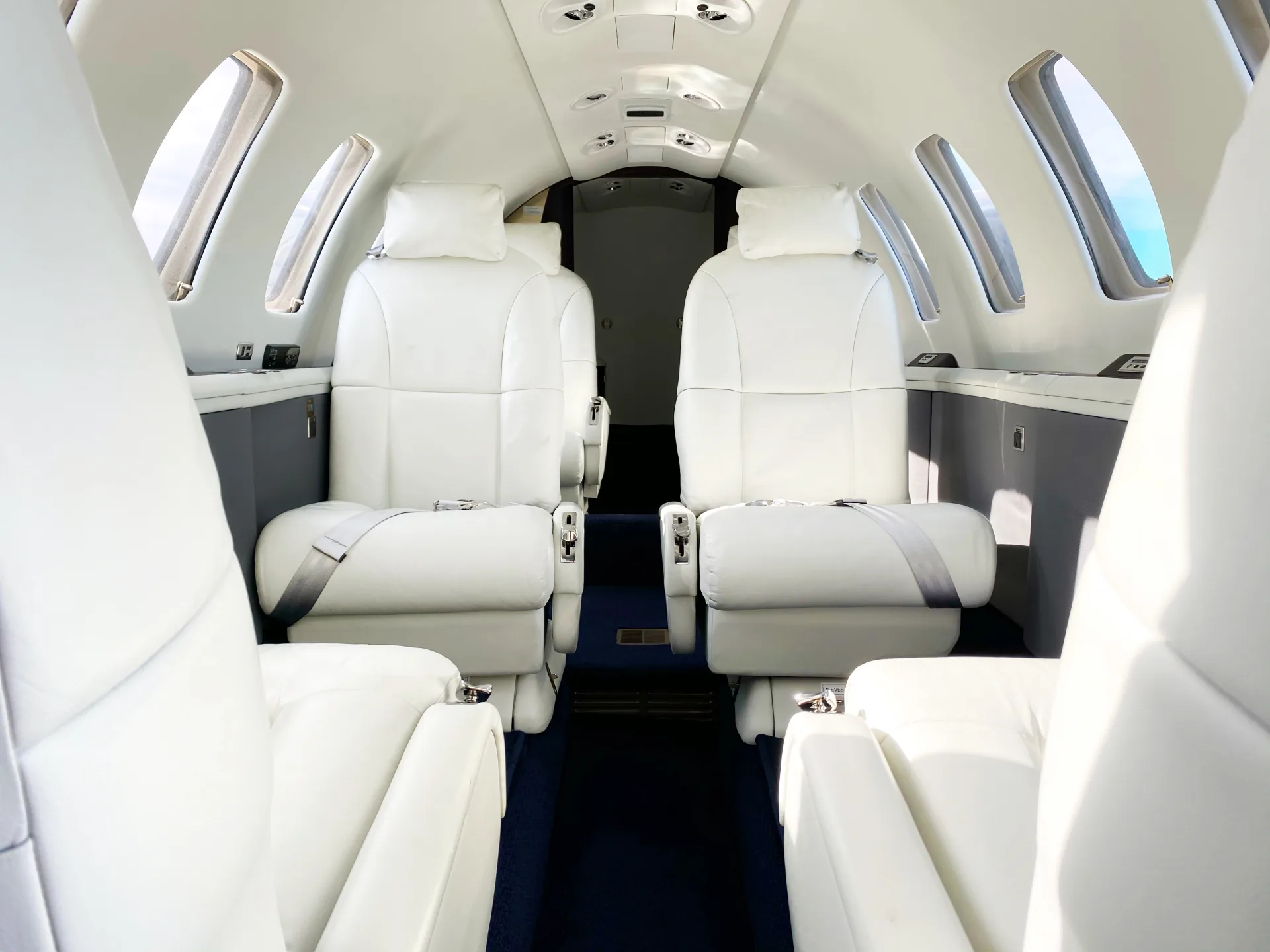 Interior view of the aircraft cabin with white leather seats.