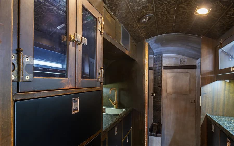 Aircraft interior with a sink and storage cabinets.