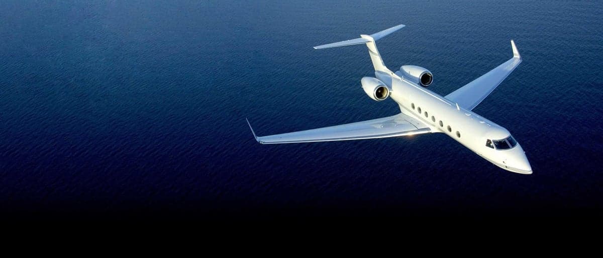 A Gulfstream jet flying over the ocean.