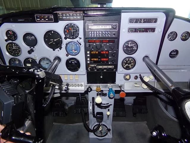 The instrument panel of a Cessna 182, featuring various gauges, radios, and controls.