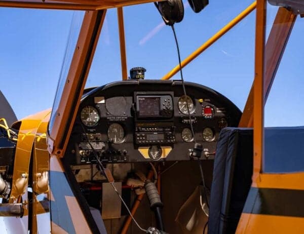 A view of the Legend Cub's cockpit, showing the instrument panel with various gauges and a GPS unit.