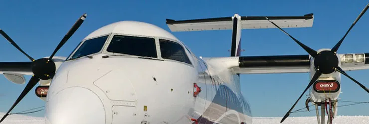 Close-up of a white turboprop aircraft's nose and propellers.