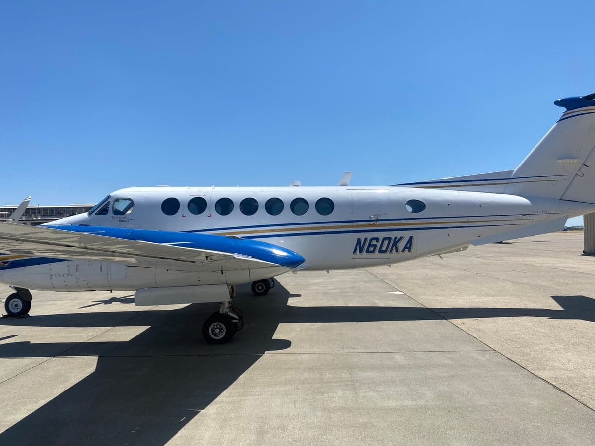 A full side view of the white and blue Beechcraft King Air 350 with registration N60KA parked on the tarmac.