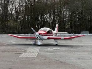 Front view of a white and red aircraft with German flag on the tail, parked on the tarmac.