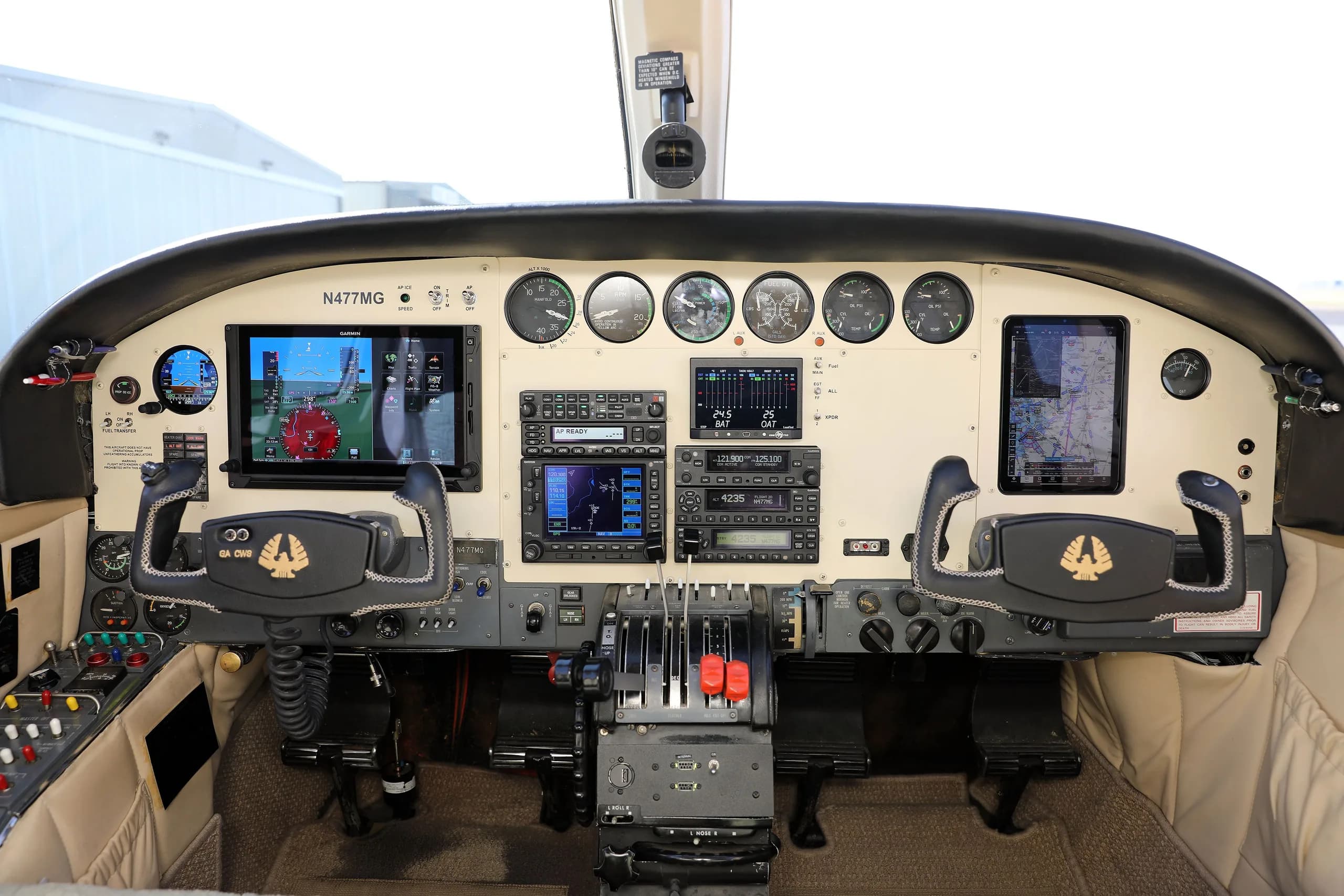 The cockpit instrument panel of the Cessna 414 Chancellor, N477MG, featuring modern avionics and dual yokes.