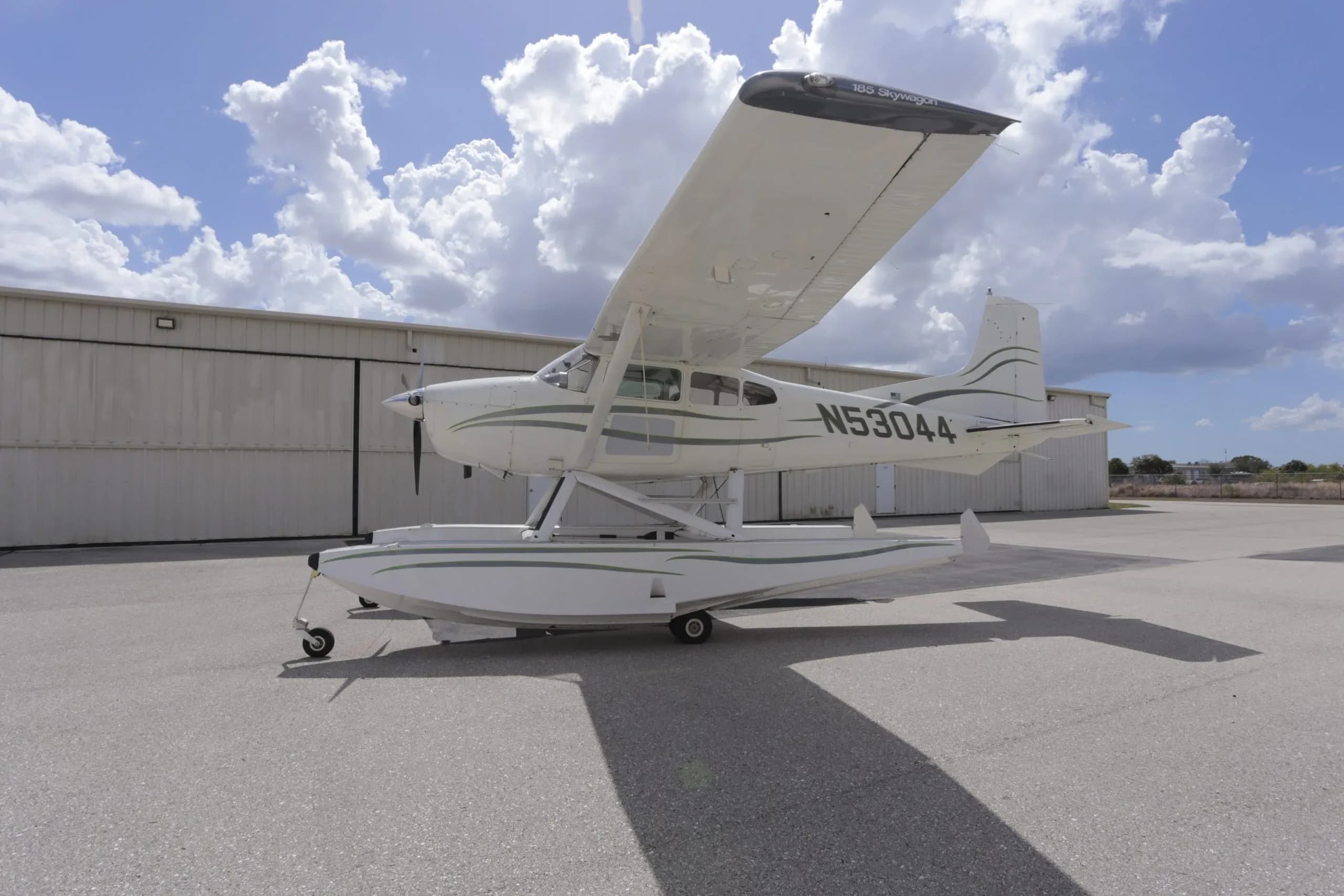 A black and white single-engine turboprop aircraft with orange flame decals is parked on a patterned tarmac.