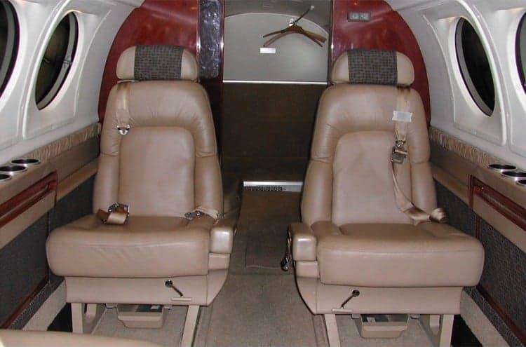 Two leather seats inside the aircraft cabin.