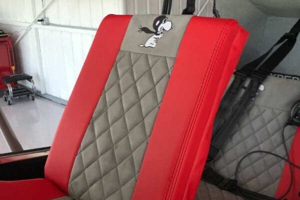 Close-up of the aircraft's red and gray seat with a Snoopy logo.