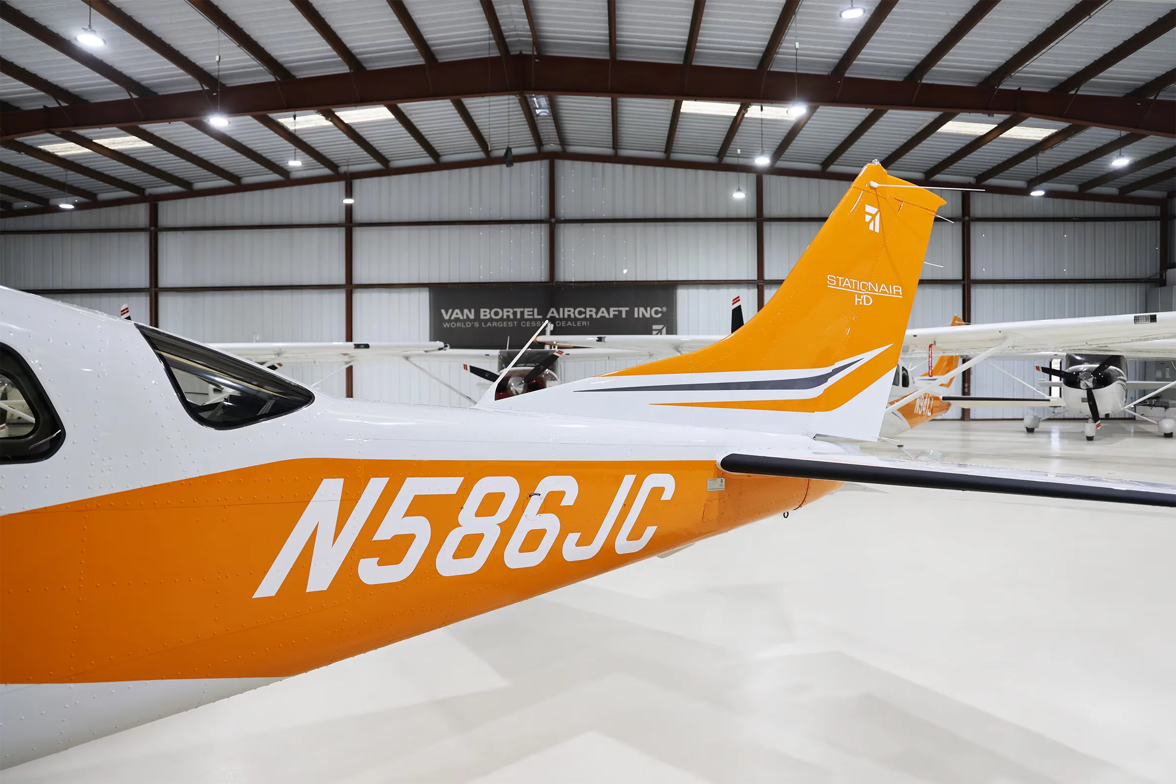 Tail section of N586JC Cessna Stationair T206H in a hangar.