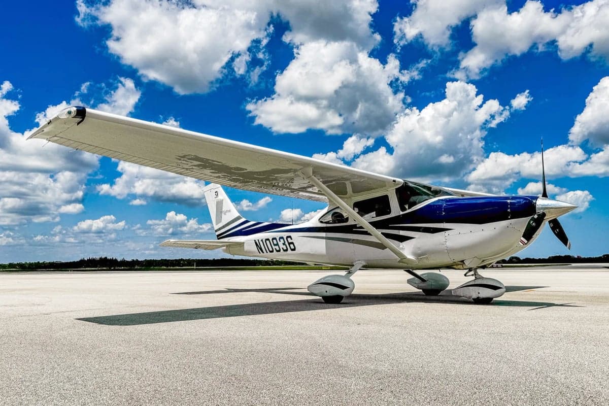 A Cessna 182 Skylane, registration N10936, parked on the tarmac under a cloudy sky.