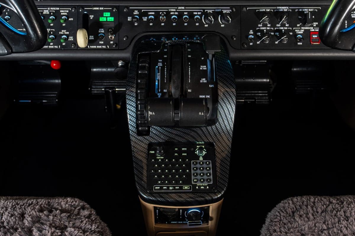 A detailed view of the center console in the Cessna Citation M2 cockpit, featuring the throttle quadrant and control panel.