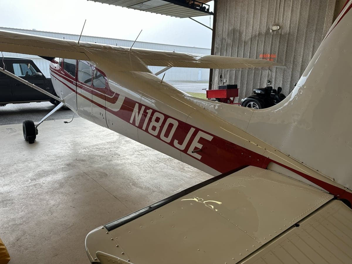Side view of N180JE showing the red and white paint scheme.