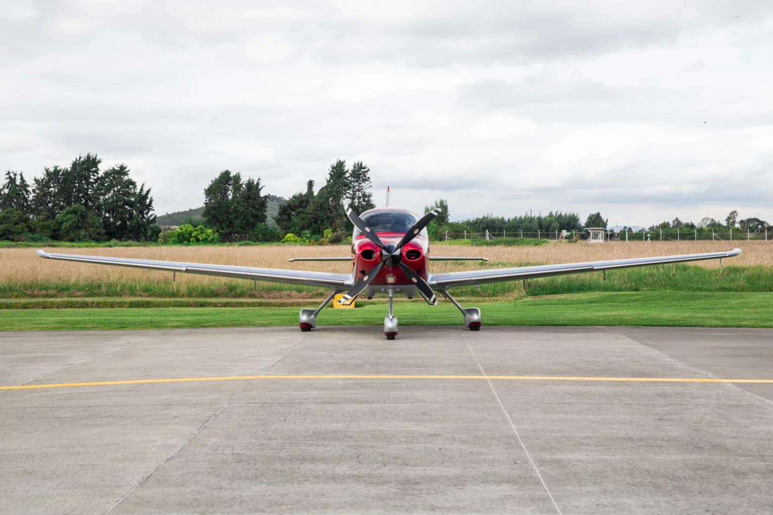 Front view of a red and silver Cirrus SR22T aircraft, registration N785SY, parked on an airfield.