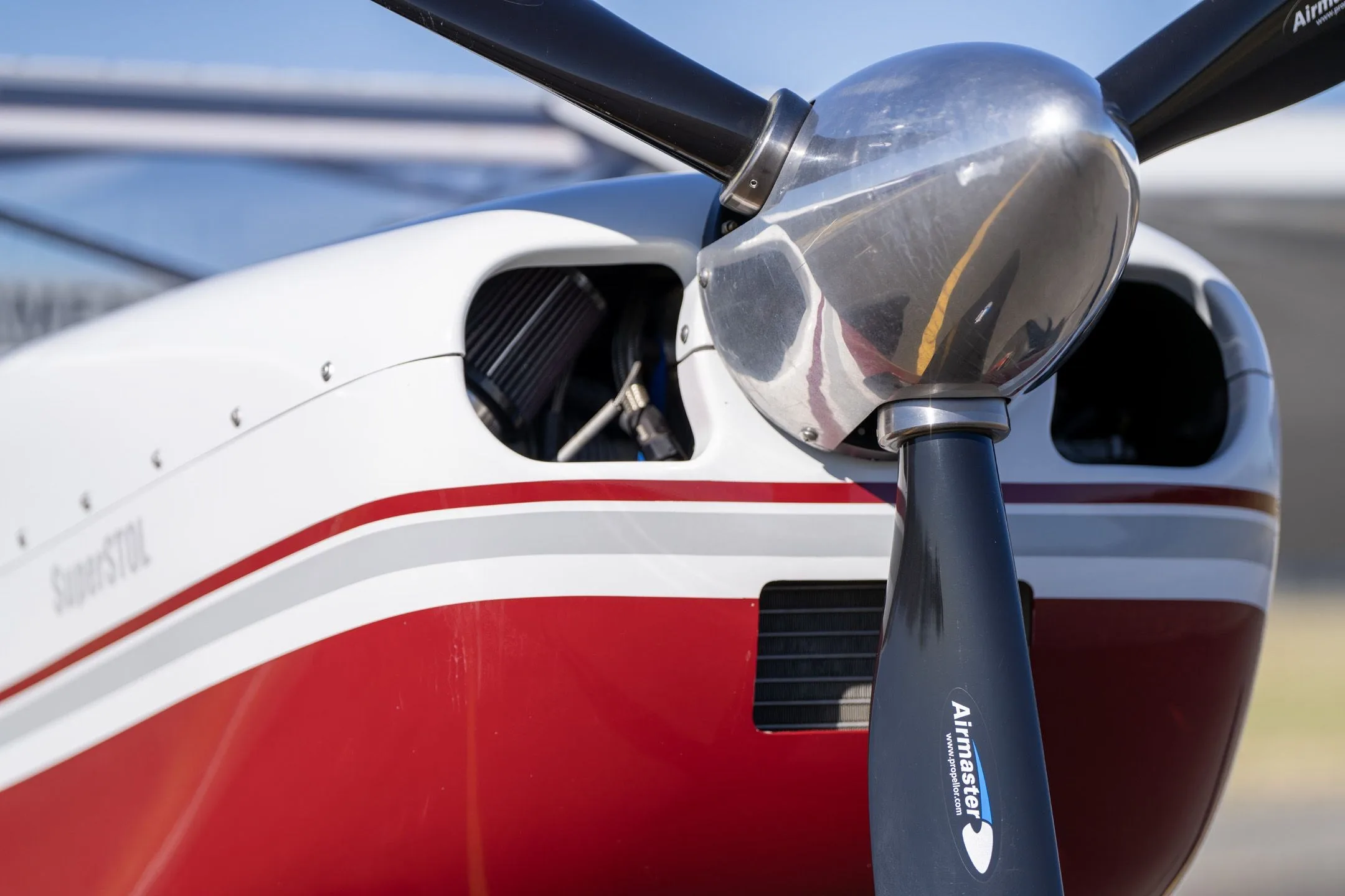 Close-up of the engine cowling and propeller of a red and white Just Aircraft SuperSTOL.