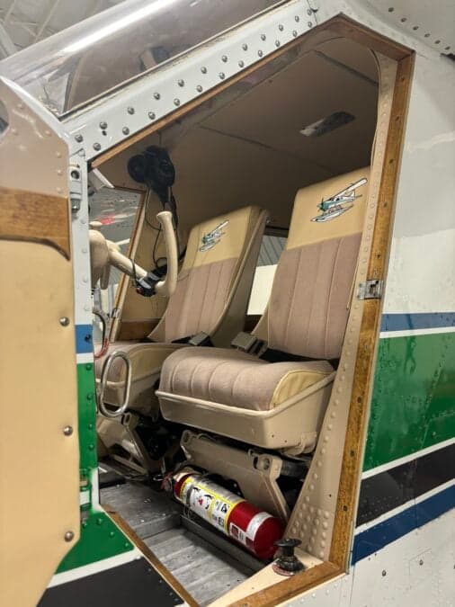 View of the front seats in the cabin, with a logo on the headrests.
