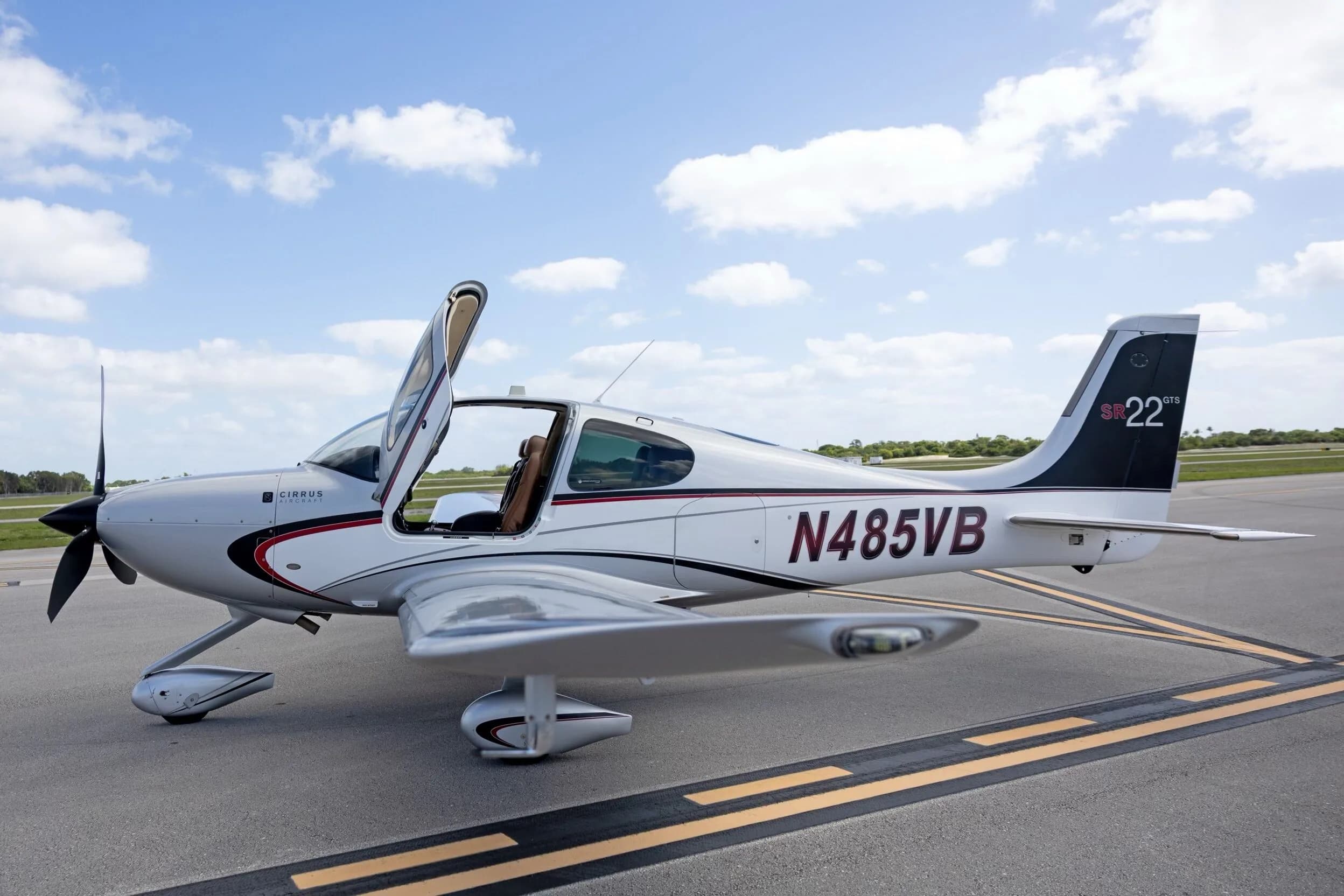 A side view of the silver Cirrus SR22 GTS aircraft N485VB with the front door open, highlighting the interior.
