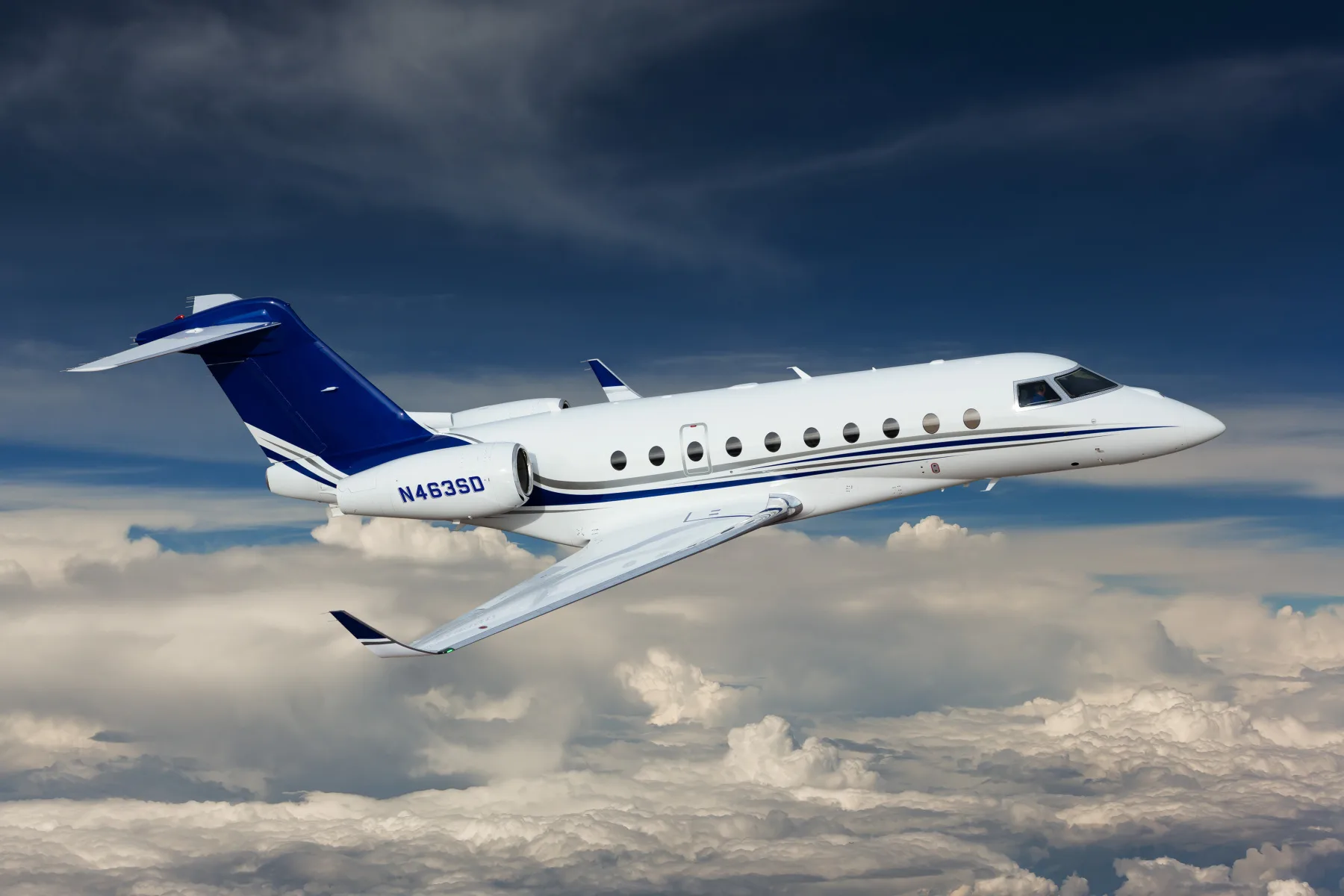 Gulfstream aircraft in flight with blue and white paint scheme.