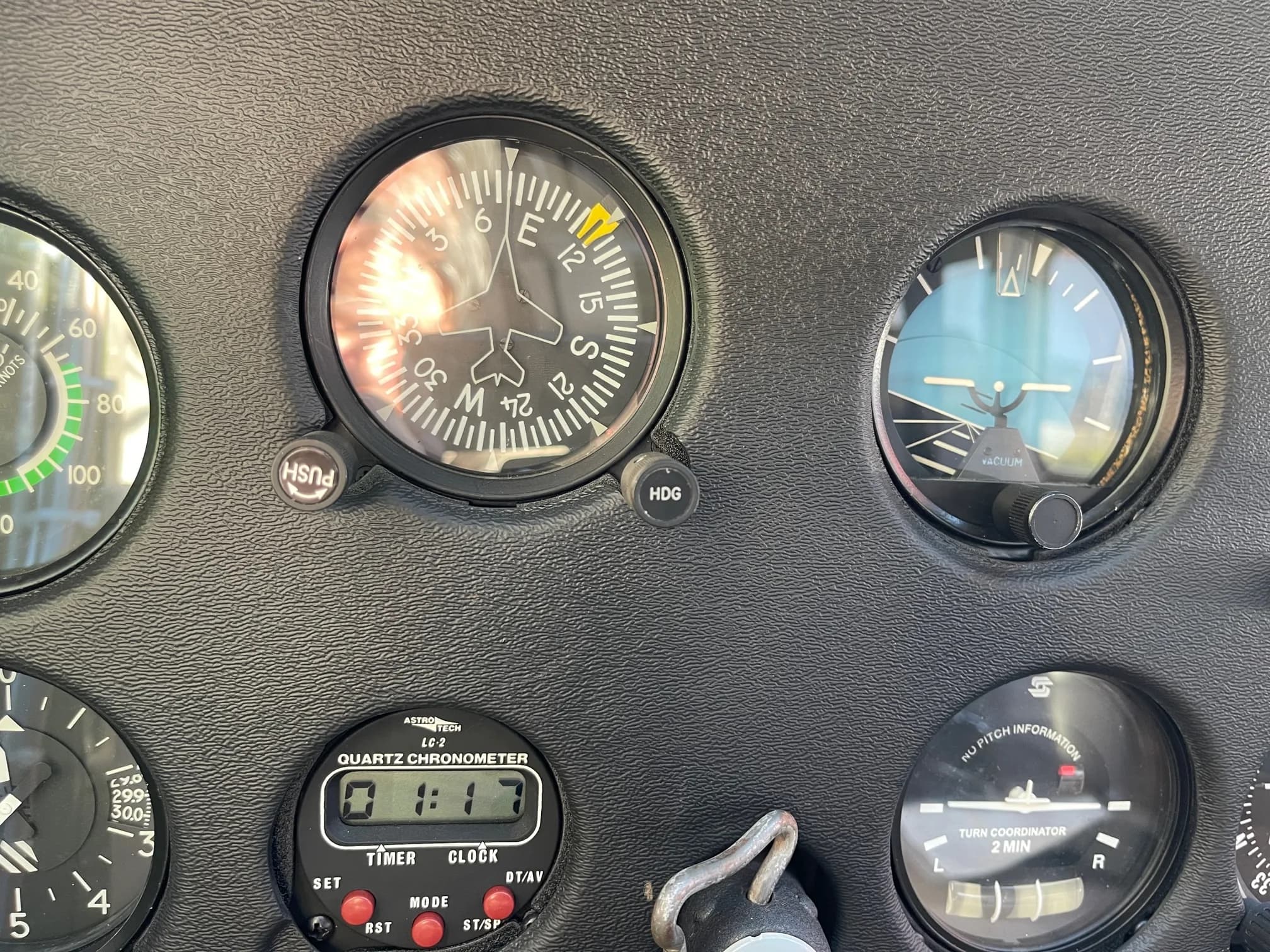 Close-up of the compass and other gauges on the instrument panel of an aircraft.