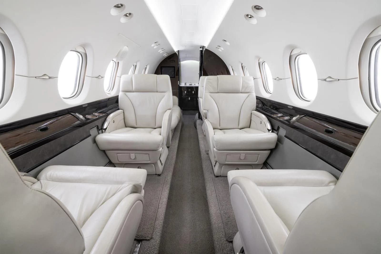 The aircraft's cabin interior with rows of light-colored leather executive seats.