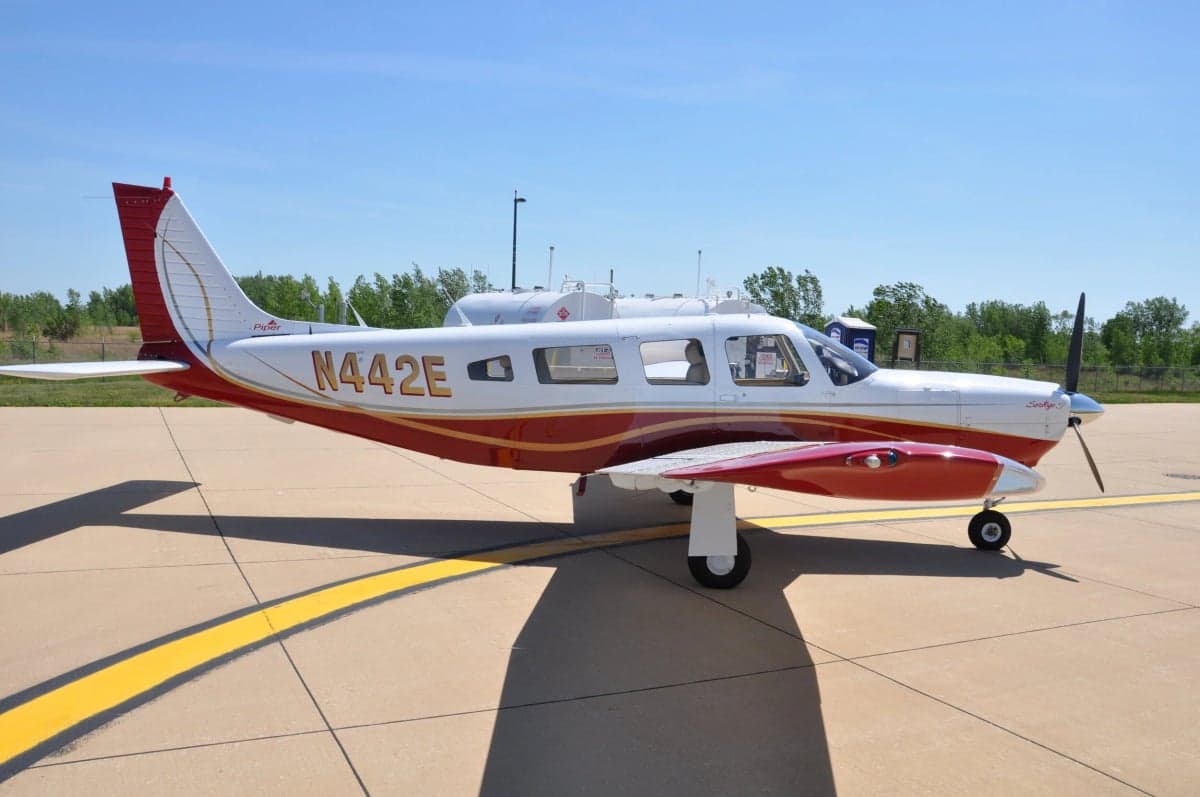Side view of a Piper Saratoga with red and white paint scheme.